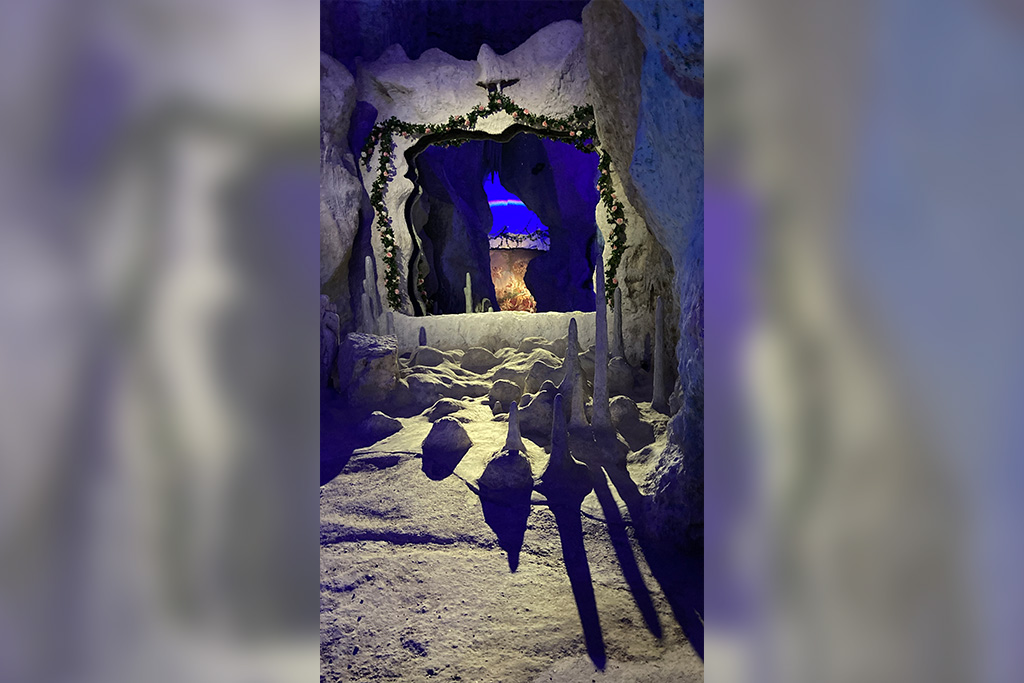 Schattenwurf der Stalagtiden im Vordergrund und im Hintergrund ein Regenbogen im inneren der Grotte